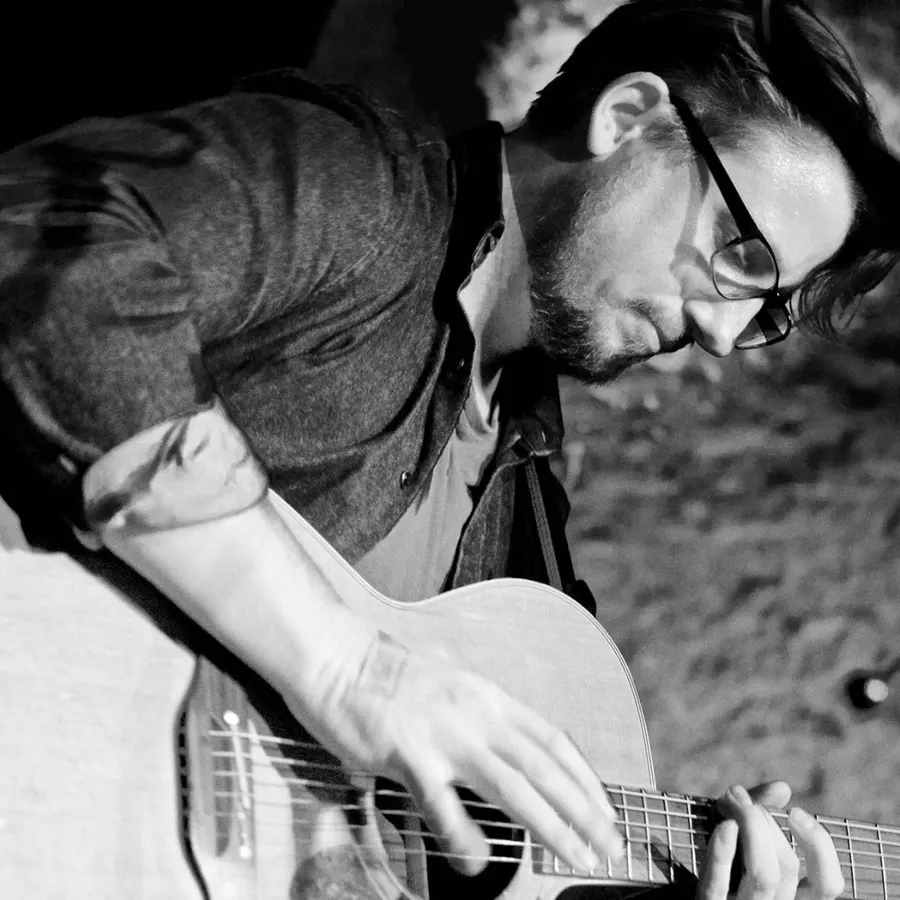 Ryan Inglis playing acoustic guitar, close up on his fretting hand